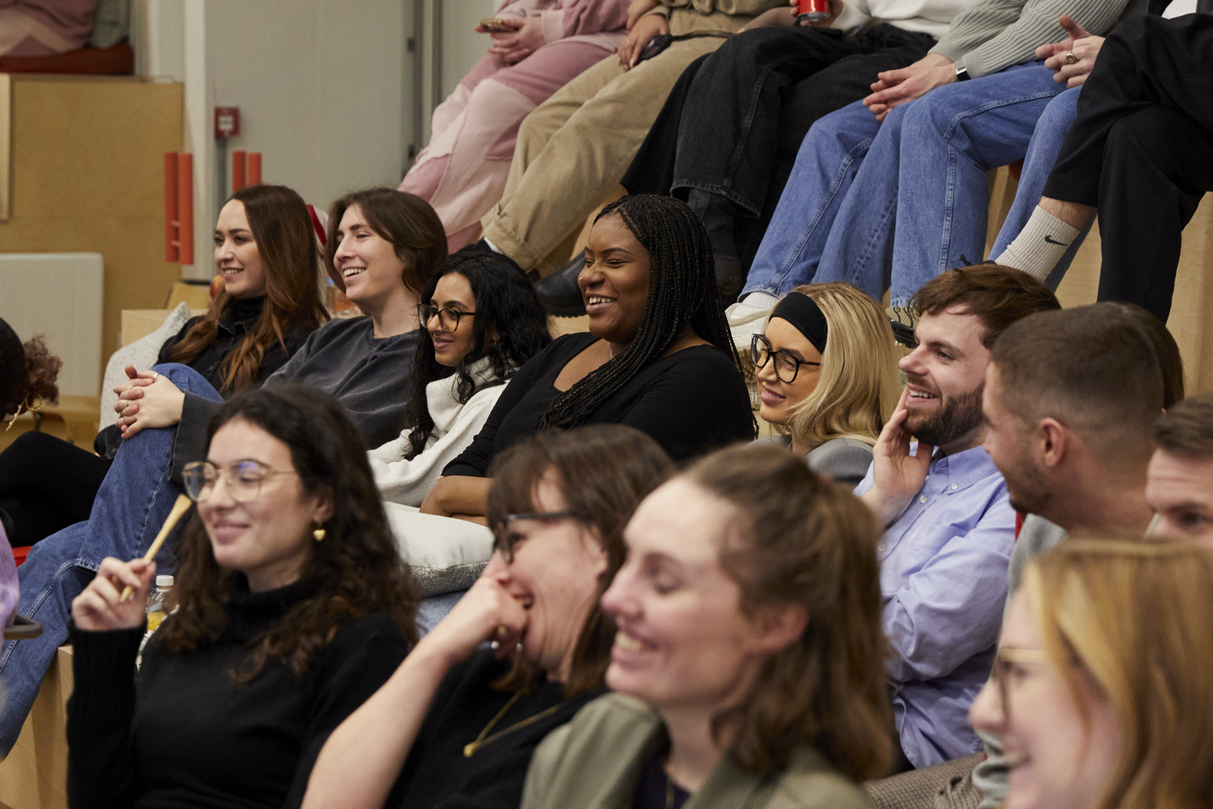 A group of people in a hall are laughing